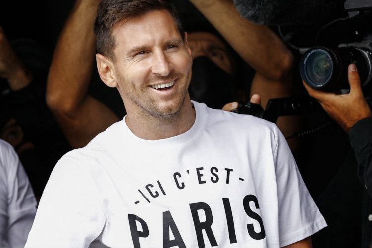 Messi acena para fãs em aeroporto de Paris. Ele formará um trio estrelado no PSG com Neymar e Mbappé