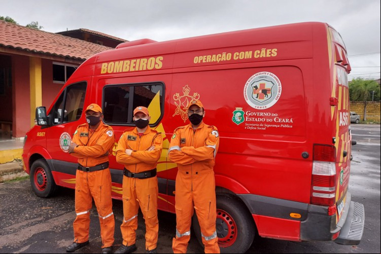 Uniforme utilizado atualmente será substituído por novo fardamento. Na foto, feita em janeiro de 2022, três bombeiros posam para foto com os braços cruzados ao lado de uma viatura