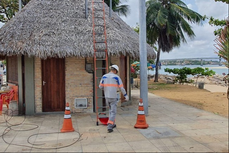 Funcionário da Enel realiza instalação de energia elétrica em quiosque da Barra do Ceará