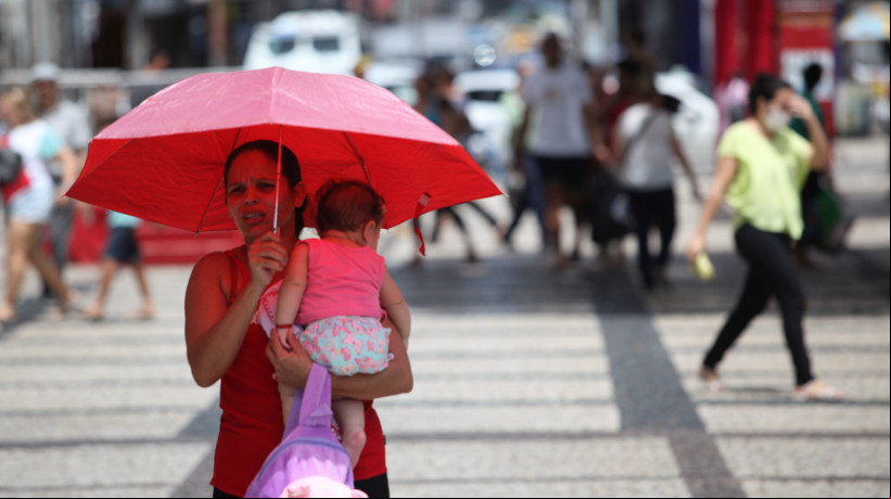As temperaturas máximas devem variar entre 32 graus Celsius ( °C) e 36 °C em grande parte do Estado até esta quarta-feira, 21. Em Fortaleza, são esperados números em torno de 32 °C. Na imagem, mulher se protege do sol na Praça do Ferreira, na Capital, em 2023