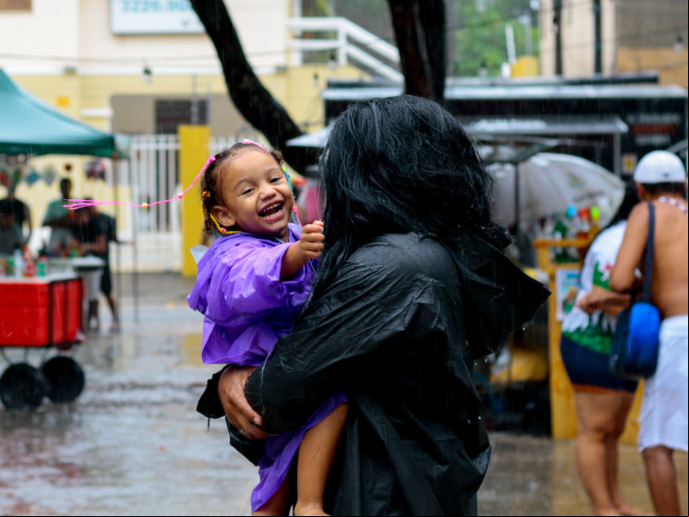 FORTALEZA, CEARÁ, BRASIL, 01-03-2025: Arthur França, a esposa Teofilana Soares e filhos em movimentação de foliões mesmo em chuva forte se divertindo no polo de Carnaval do Benfica com as atrações da banda Luxo da Aldeia. (Foto: Samuel Setubal/ O Povo)