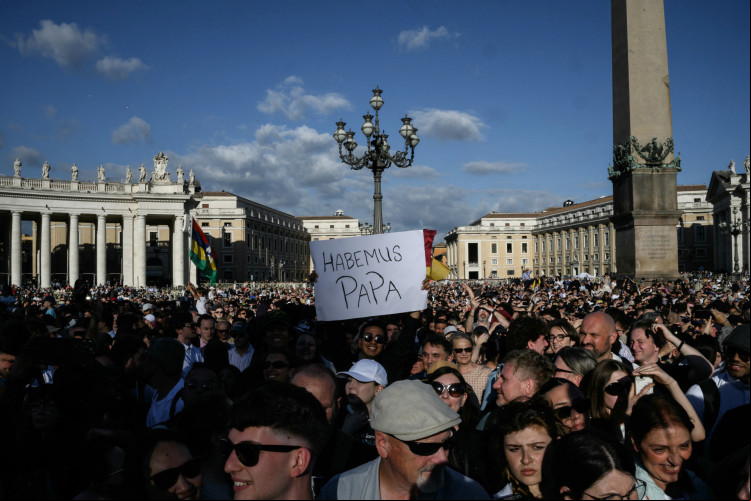 Homem segura cartaz com a frase: "Habemus Papa", depois que a fumaça branca saiu da chaminé da Capela Sistina, indicando que o novo papa fopi escolhido Homem segura cartaz com a frase: "Habemus Papa", depois que a fumaça branca saiu da chaminé da Capela Sistina, indicando que o novo papa fopi escolhido