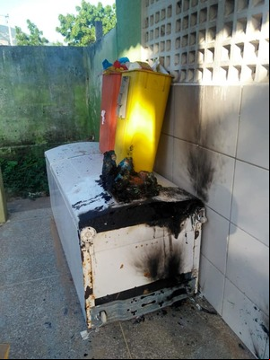 Geladeira queimada caída no chão  